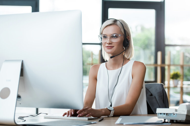 Frau mit Headset am Computer - Depositphotos_285781162_XL